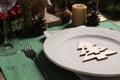 Festive place setting with beautiful dishware, cutlery and decor for Christmas dinner on wooden table, closeup Royalty Free Stock Photo