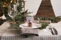 Festive place setting with beautiful dishware, cutlery and gingerbread house card holder for Christmas dinner on wooden table Royalty Free Stock Photo