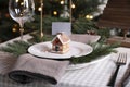 Festive place setting with beautiful dishware, cutlery and gingerbread house card holder for Christmas dinner on wooden table Royalty Free Stock Photo