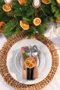 Festive place setting with beautiful dishware, fabric napkin and dried orange slice for Christmas dinner on white table, flat lay Royalty Free Stock Photo