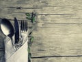 Festive place setting for christmas dinner. Vintage cutlery on the white napkin and fir cone on the old wooden background with Royalty Free Stock Photo