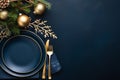 Festive place setting for Christmas eve, New year dinner. Top view to empty plates and gold cutlery on navy blue