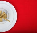 Table setting detail and gift on red tablecloth Royalty Free Stock Photo