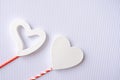 Festive postcard flatlay on Valentine`s Day. Large 3D white hearts on a white background with red bright legs