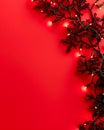 Festive Red Background with Glowing Christmas Lights and Decorative Branches for Holiday Design Royalty Free Stock Photo
