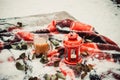 Festive red candle in lantern and mug of coffee on rug with snow Royalty Free Stock Photo