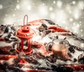 Festive red candle in lantern and mug of coffee on rug with snow Royalty Free Stock Photo