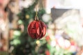 Festive Red Diamond Pattern Christmas Ornament Hanging on Blurred Tre Royalty Free Stock Photo