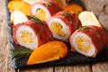 Festive roll of pork baked in prosciutto and stuffed with persimmon and cheese close-up. horizontal Royalty Free Stock Photo