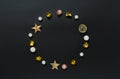 Festive round frame made of gold, sparkling and white ornaments, balls on a black background. Concept of Christmas and