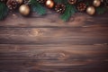 Festive rustic Christmas frame composed of pine branches, pine cones and Christmas decorations on a rustic wooden background. Royalty Free Stock Photo