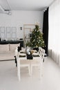 Festive set dining table in the living room in black and white colors on the background of the Christmas tree Royalty Free Stock Photo