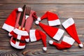 Festive set of fork and knife on wooden background. Top view of new year decorations and santa clothes and hat. Close up of Royalty Free Stock Photo