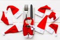 Festive set of fork and knife on wooden background. Top view of new year decorations and santa clothes and hat. Close up of Royalty Free Stock Photo