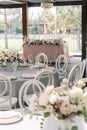 Festive setting in the restaurant for a solemn wedding banquet. Round tables and stylish guest chairs