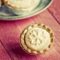 Festive shortcrust pastry mince pies. A sweet mince pie, a traditional rich festive food on red wooden background. Royalty Free Stock Photo