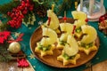 Festive snack of canapes on the Christmas table. Fruit canapes with cheese, kiwi and pineapple. Royalty Free Stock Photo