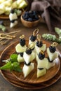 Festive snack of fruit and berry canapes. Halloween party food. Canapes with melon and blackberries on a wooden table.