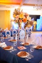 Festive table with blue cloth, napkins, plates, cutlery and glasses prepared for wedding guests in restaurant. Beautiful Royalty Free Stock Photo