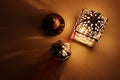 Festive table composition of glowing Moroccan ornamental lanterns and bronze tea cup. Decorative golden shadows Royalty Free Stock Photo