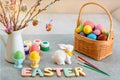 Festive table decoration for Easter holiday with flowers and eggs. basket full of eggs and rabbit figurine