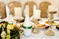 Festive table for guests, decorated with white candles, a bottle and the bouquet of flowers. Wedding banquet. Royalty Free Stock Photo