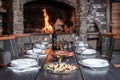 Festive table indoors with different dishes and red wine, bonfire background