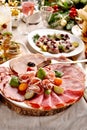 Festive table with a platter of sliced ham and cured meats and herrings  for Christmas Royalty Free Stock Photo