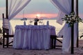 Festive table by the sea. Decorated for a romantic dinner. Against the backdrop of sunset, yachts and mountains Royalty Free Stock Photo