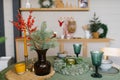 Festive table set in the kitchen for Christmas and New Year. Spruce branches in a vase, glass glasses, a candle, a wreath on the Royalty Free Stock Photo