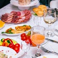 Festive table setting with crystal glasses and plates. Snacks and sandwiches on the table