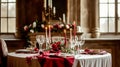 Festive table setting with cutlery, candles and beautiful red flowers in vase Royalty Free Stock Photo