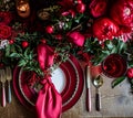 Festive table setting  with cutlery, candles and beautiful red flowers in vase Royalty Free Stock Photo