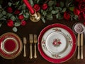 Festive table setting with cutlery, candles and beautiful red flowers in vase Royalty Free Stock Photo