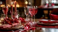 Festive table setting with cutlery, candles and beautiful red flowers in vase Royalty Free Stock Photo