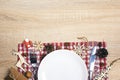 Festive table setting with cutlery, checkered napkin and Christmas decorations on wooden table. Copy space. Top view. Royalty Free Stock Photo