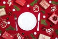 Festive table setting with cutlery and Christmas decorations on red cloth background. Christmas tableware Royalty Free Stock Photo