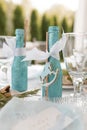 Festive table setting with decorated brilliant blue bottle of drink on white tablecloth closeup. Decorations, event Royalty Free Stock Photo