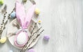 Festive table setting for Easter. A napkin in the form of an Easter bunny on a plate surrounded by colorful Easter eggs. Light
