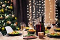 Festive table setting. Food and drinks, plates and glasses. Evening lights and candles. New Year`s Eve. Royalty Free Stock Photo