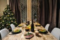 Festive table setting. Food and drinks, plates and glasses. Evening lights and candles. New Year`s Eve. Royalty Free Stock Photo