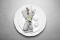 Festive table setting with painted eggs and willow twig on grey background, top view. Easter celebration