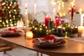 Festive table setting in room decorated for Christmas, closeup. Bokeh effect Royalty Free Stock Photo