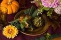 Festive table setting for Thanksgiving day. Autumnal decorations,plates, multicolor glasses and beautiful garden flowers Royalty Free Stock Photo