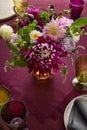 Festive table setting for Thanksgiving day. Autumnal decorations,plates, multicolor glasses and beautiful garden flowers Royalty Free Stock Photo