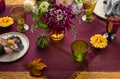 Festive table setting for Thanksgiving day. Autumnal decorations,plates, multicolor glasses and beautiful garden flowers Royalty Free Stock Photo