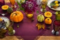 Festive table setting for Thanksgiving day. Autumnal decorations,plates, multicolor glasses and beautiful garden flowers Royalty Free Stock Photo