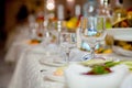 Festive tableware with glasses on a table. Empty glasses stand near plates and forks on banquet table decorated with white Royalty Free Stock Photo