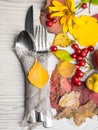 festive thanksgiving autumn cutlery setting and arrangement of colorful fall leaves, red berries Royalty Free Stock Photo