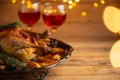 The festive thanksgiving dinner with traditional turkey on the plate and two glasses red wine isolated on wooden background with